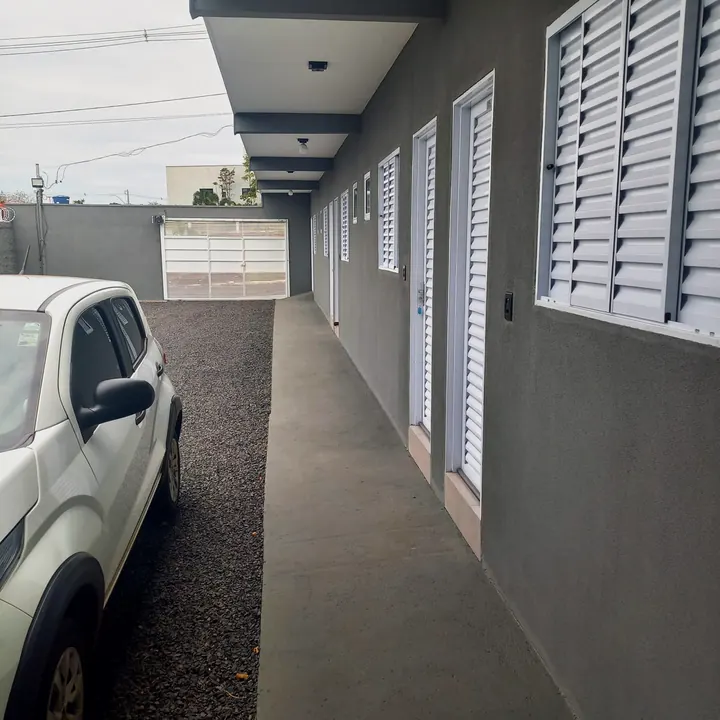 Área externa da pousada com circulação coberta e área verde